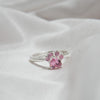 Anillo Patita rosa en plata con un diseño de patita y gemas rosas, presentado sobre tela blanca suave-el regalo ideal para amantes de mascotas.