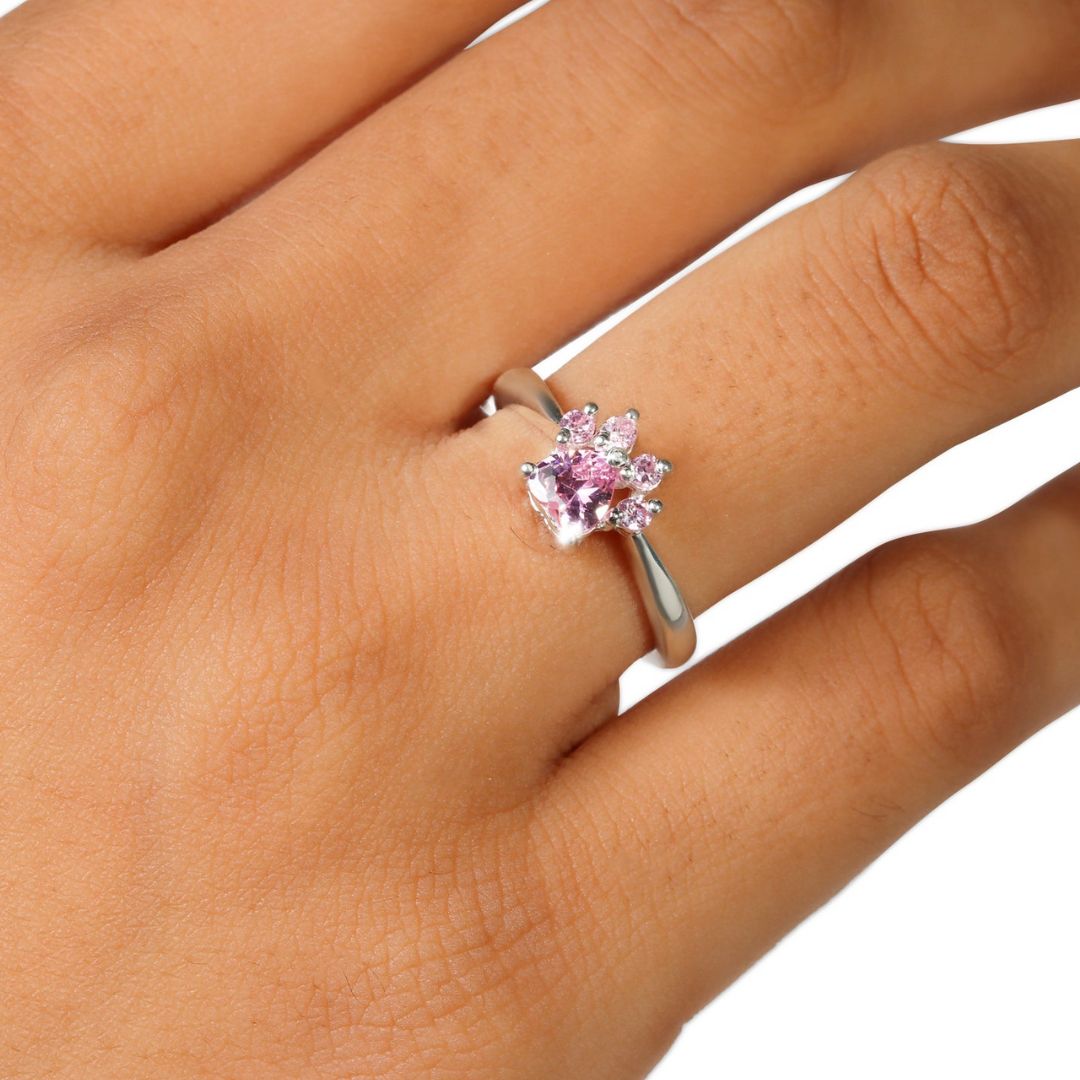 Primer plano de una mano que lleva en el dedo anular el Anillo Patita rosa, un anillo de plata con una piedra preciosa rosa en forma de garra, que lo convierte en el regalo perfecto para los amantes de las mascotas.
