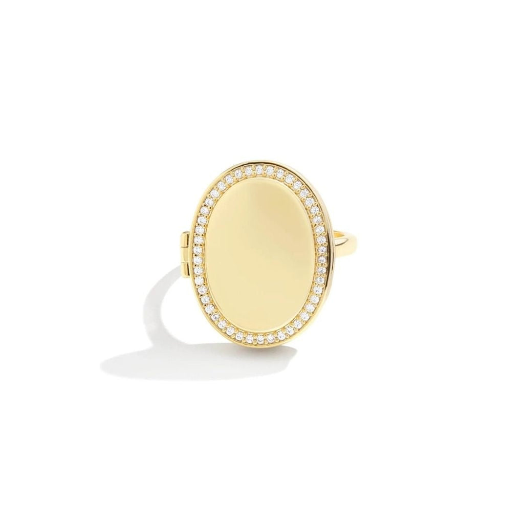Anillo personalizado con foto en forma ovalada de oro, centro liso y pulido, rodeado de pequeños diamantes brillantes, mostrado sobre fondo blanco.