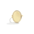 Anillo personalizado con foto en forma ovalada de oro, centro liso y pulido, rodeado de pequeños diamantes brillantes, mostrado sobre fondo blanco.