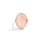 Un Anillo de oro rosa personalizado con foto con un centro liso, rodeado de brillantes diamantes, sobre un fondo blanco con una suave sombra, ideal como regalo personalizado.