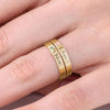 Primer plano de una mano que lleva dos anillos apilables con nombres y piedras de nacimiento en un dedo, personalizados con 