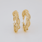 Aretes colgantes en espiral de acero inoxidable dorado, con diseño retorcido e intrincados detalles texturizados, expuestos sobre un fondo blanco.