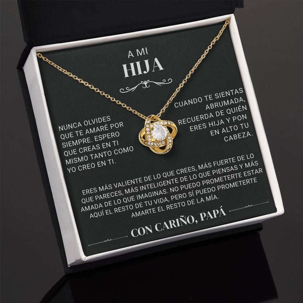 El "Collar 'A mi hija' - Con cariño Papá" es un collar de oro con un colgante de corazón, presentado en una caja de regalo negra con un mensaje en español de padre a hija, expresando amor y ánimo.