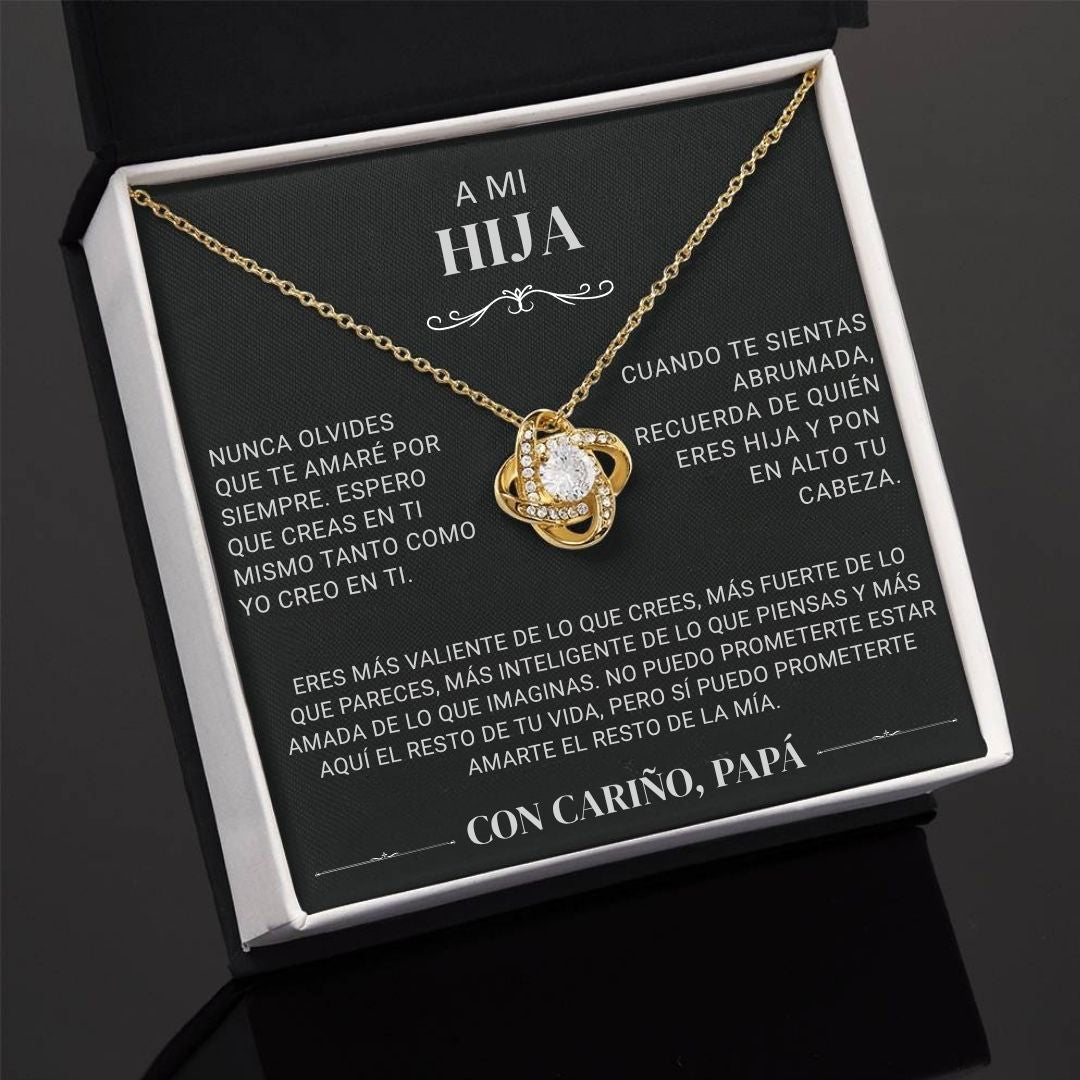 El "Collar 'A mi hija' - Con cariño Papá" es un collar de oro con un colgante de corazón, presentado en una caja de regalo negra con un mensaje en español de padre a hija, expresando amor y ánimo.