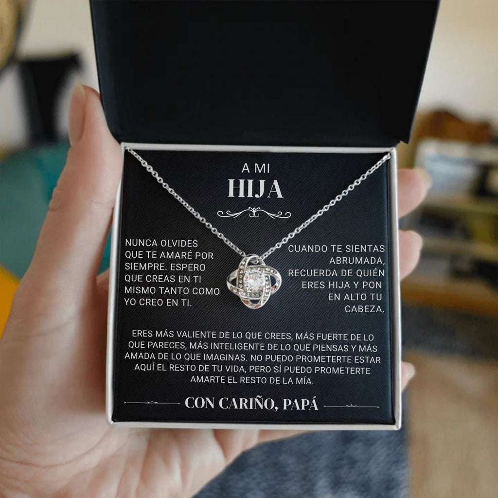 Una persona sostiene un joyero negro abierto que muestra el collar "A mi hija" - Con cariño Papá, con un collar de plata y una sentida nota en español dentro de la tapa, de padre a hija, expresando amor, orgullo y ánimo.