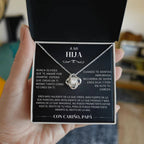 Una persona sostiene un joyero negro abierto que muestra el collar "A mi hija" - Con cariño Papá, con un collar de plata y una sentida nota en español dentro de la tapa, de padre a hija, expresando amor, orgullo y ánimo.