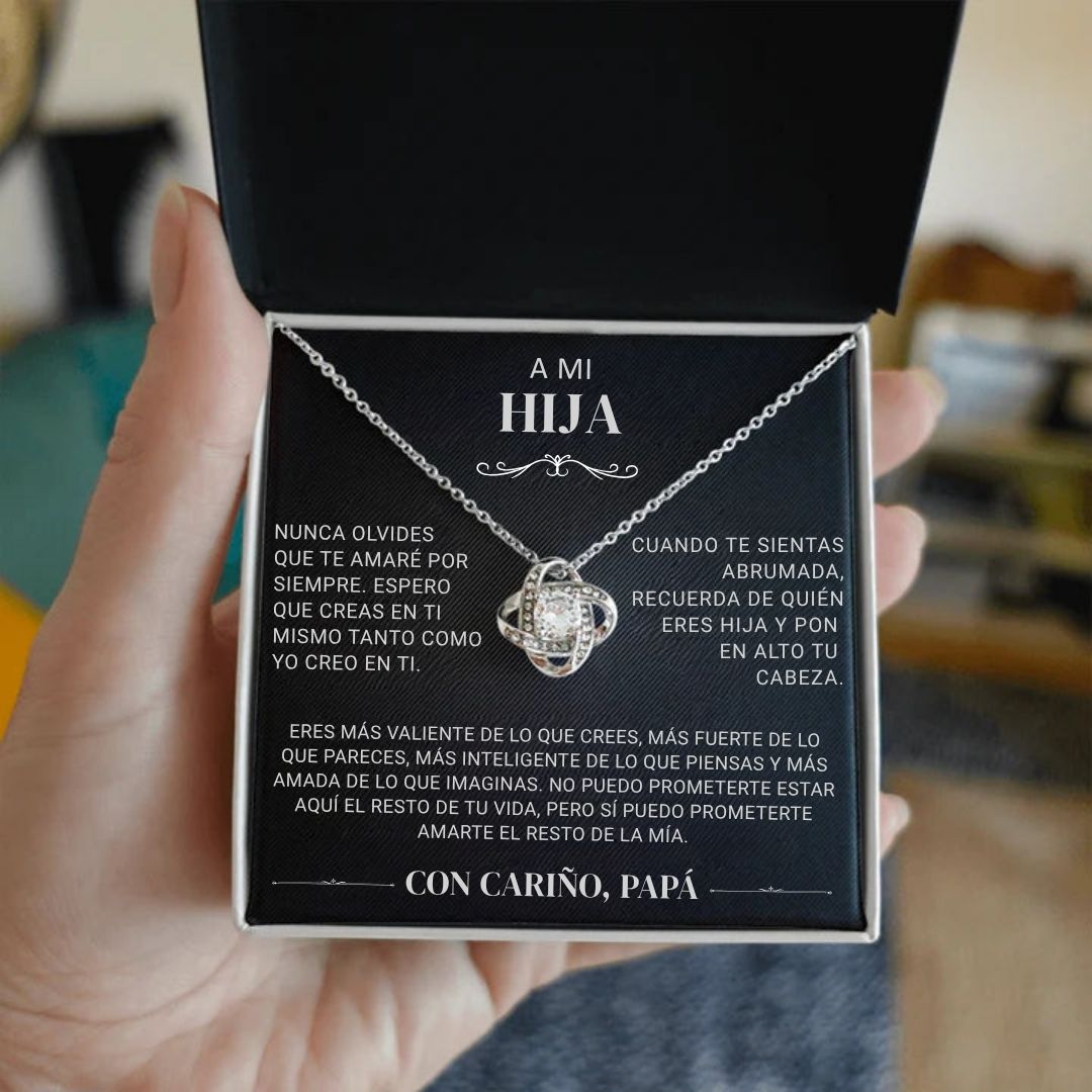 Una persona sostiene un joyero negro abierto que muestra el collar "A mi hija" - Con cariño Papá, con un collar de plata y una sentida nota en español dentro de la tapa, de padre a hija, expresando amor, orgullo y ánimo.