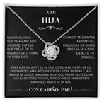 El collar "A mi hija" - Con cariño Papá es un collar de plata con un colgante entrelazado y una gema central, sobre una tarjeta negra con un sentido mensaje en español de papá a hija, expresando amor, ánimo y apoyo.