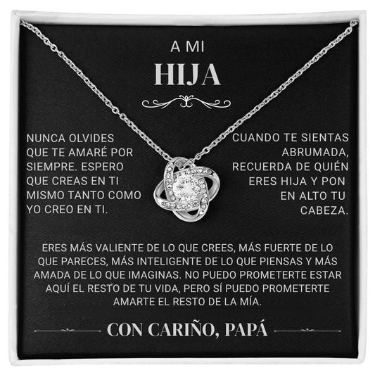 El collar "A mi hija" - Con cariño Papá es un collar de plata con un colgante entrelazado y una gema central, sobre una tarjeta negra con un sentido mensaje en español de papá a hija, expresando amor, ánimo y apoyo.