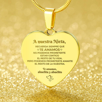 El Collar "A nuestra nieta" de corazón, grabado en español con un mensaje especial de sus abuelos, es el regalo perfecto para nietas y un recuerdo inolvidable sobre fondo dorado brillante.