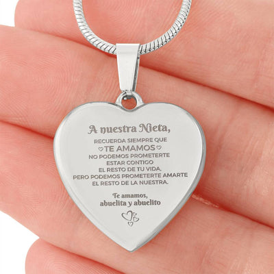 Una mano sostiene el Collar "A nuestra nieta" de corazón, grabado en español con un sentido mensaje de los abuelos-un memorable regalo abuelos nieta que simboliza su amor duradero y la promesa de quererla siempre.