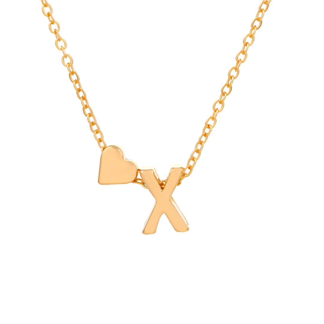 El collar con inicial y corazón presenta una delicada cadena de oro con un colgante en forma de letra "X" y un pequeño corazón en la parte superior izquierda, sobre un fondo blanco, ideal como regalo personalizado.