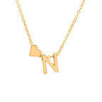 El Collar con inicial y corazón es un collar dorado con un dije de letra N y un pequeño charm de corazón a la izquierda, ideal como regalo personalizado.