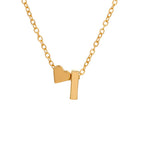 El collar con inicial y corazón es una cadena de oro con dos colgantes, un corazón y una barra rectangular brillante, uno al lado del otro. Perfecto como regalo personalizado o para combinar con tu collar con inicial favorito.