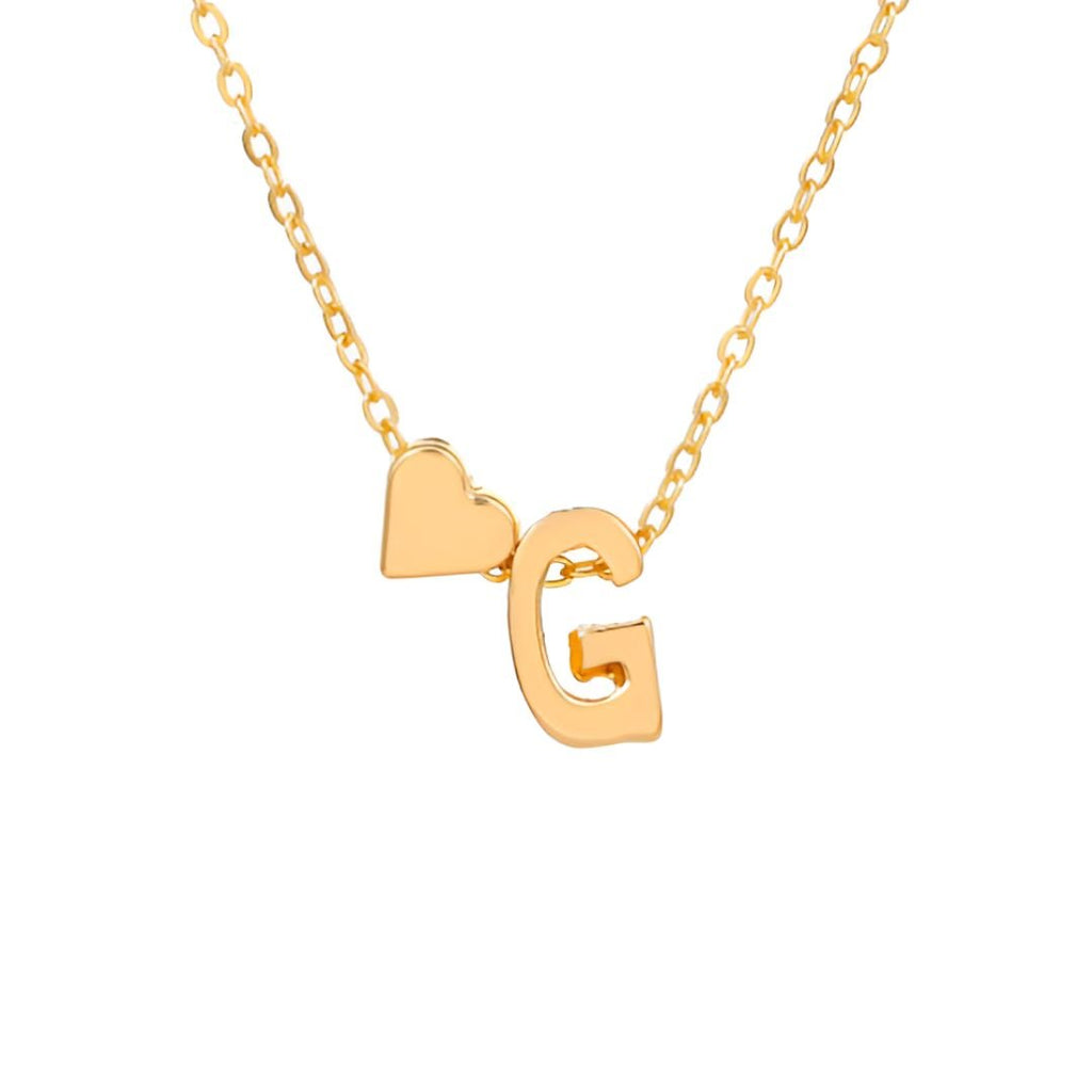 El "Collar con inicial y corazón" es un collar dorado con un dije de letra grande y un charm de corazón, ideal como regalo personalizado por su diseño elegante. Se muestra sobre fondo blanco.