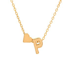 El Collar con inicial y corazón incluye una delicada cadena de oro con un pequeño corazón y un charm dorado con la letra P. Un elegante collar personalizado con ambos charms colgando uno al lado del otro, ideal como regalo personalizado.