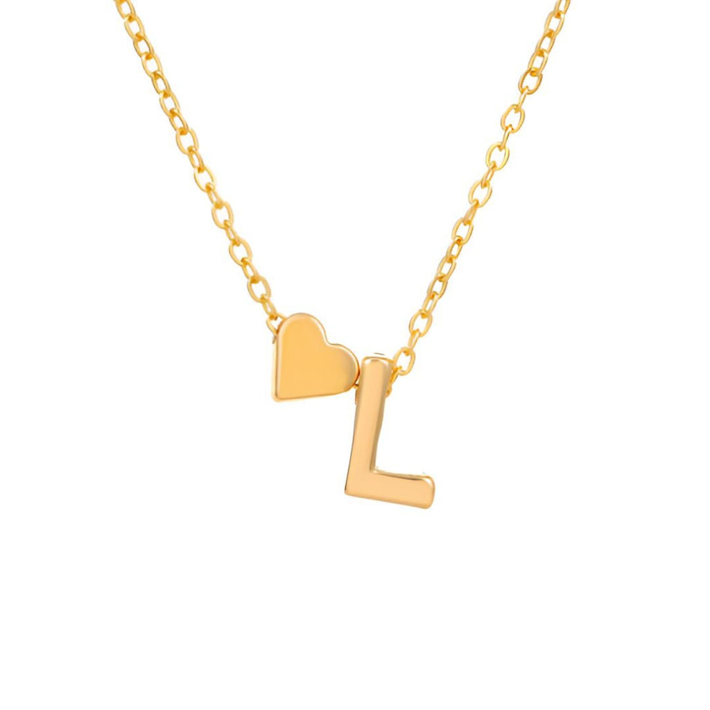 El Collar con inicial y corazón es una cadena dorada con dos dijes: un corazón pequeño y una letra L dorada, ideal como regalo personalizado. Ambos dijes cuelgan juntos en la cadena sobre fondo blanco.