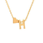Collar con inicial y corazón: una cadena dorada con dije de corazón y la letra H, ambos colgando juntos sobre fondo blanco. Un regalo personalizado ideal.