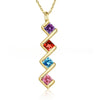Collar con múltiples piedras de nacimiento: un collar dorado con diseño en zigzag y cuatro gemas cuadradas en morado, rojo, azul y rosa. Ideal como collar personalizado o regalo para mamá que celebra piedras de nacimiento especiales.