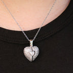 A Collar de Corazón Cofre personalizado cuelga sobre una camisa negra, mostrando un dije plateado con un pequeño corazón en el centro.