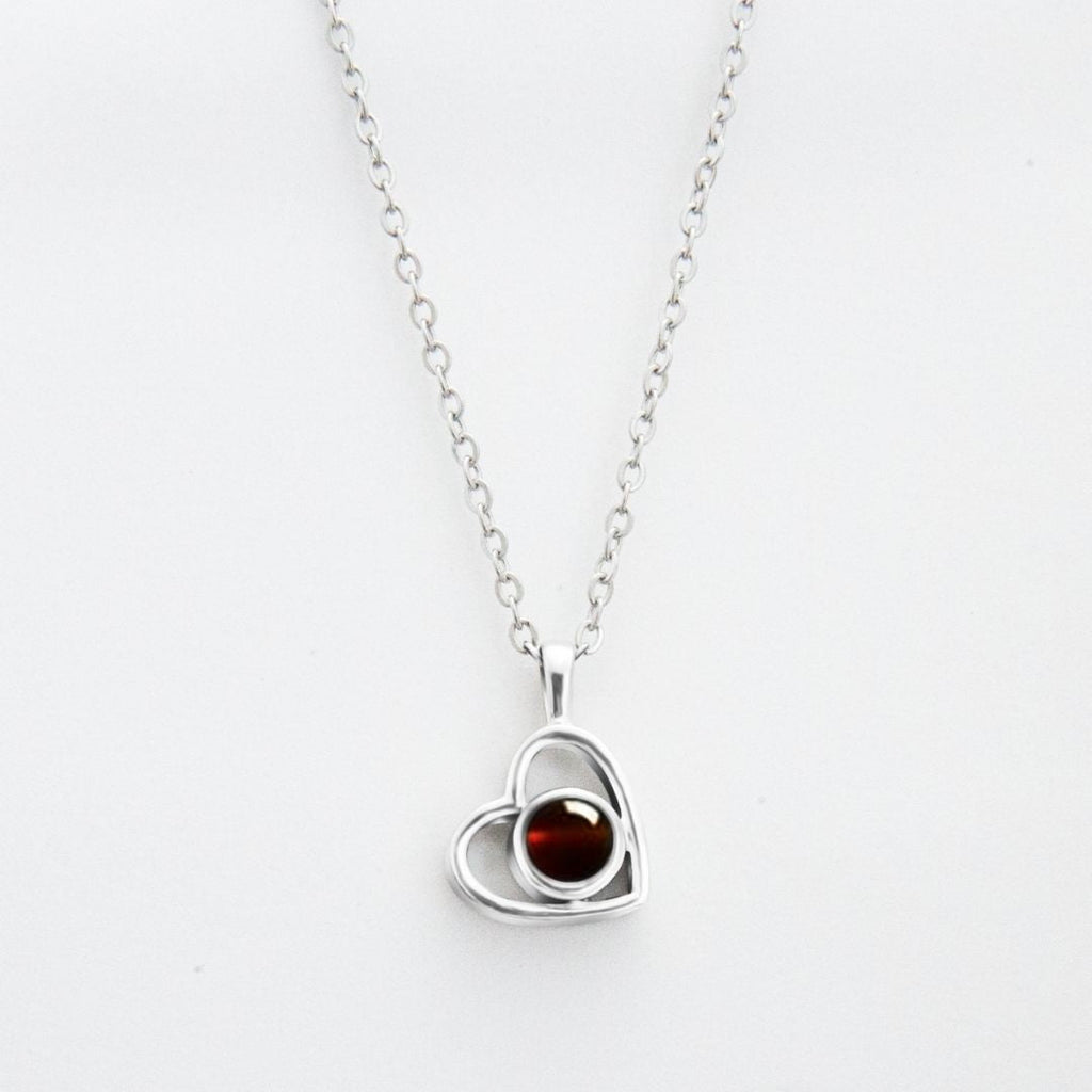 El Collar de corazón con foto es una cadena plateada con dije de corazón, ideal para recuerdos especiales o como uno de nuestros collares personalizados. El fondo es blanco.