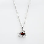 El Collar de corazón con foto es una cadena plateada con dije de corazón, ideal para recuerdos especiales o como uno de nuestros collares personalizados. El fondo es blanco.