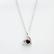 Cargar imagen en el visor de la galería, El Collar de corazón con foto es una cadena plateada con dije de corazón, ideal para recuerdos especiales o como uno de nuestros collares personalizados. El fondo es blanco.