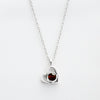 El Collar de corazón con foto es una cadena plateada con dije de corazón, ideal para recuerdos especiales o como uno de nuestros collares personalizados. El fondo es blanco.