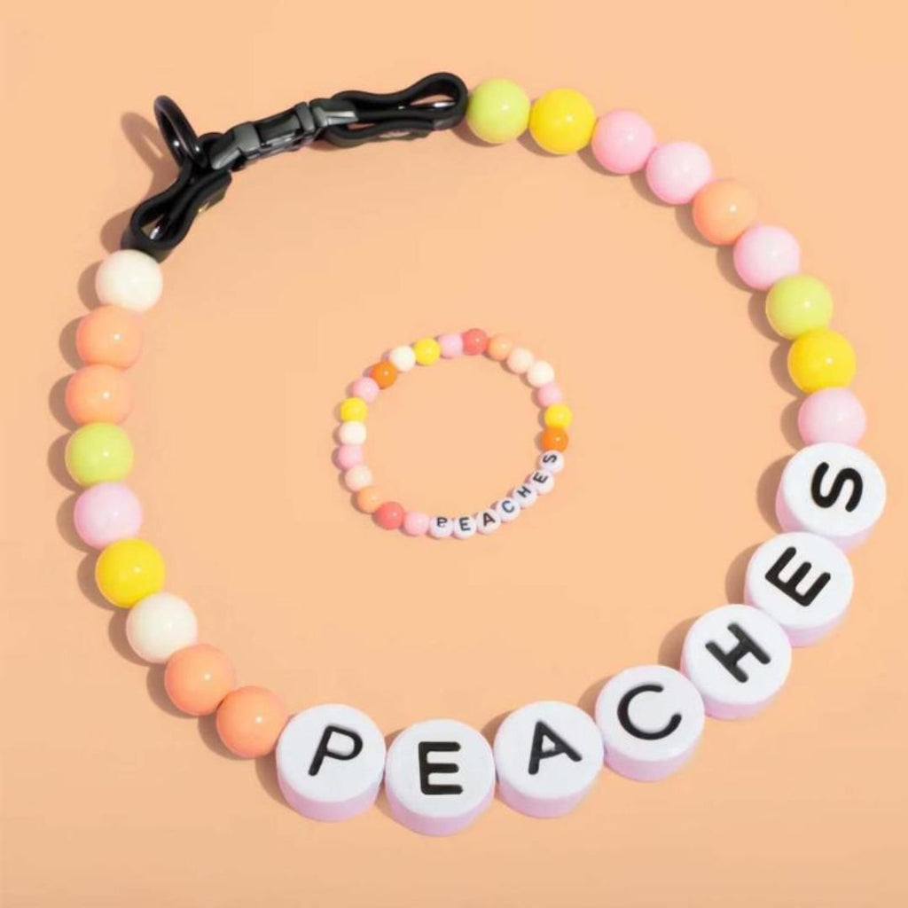 El collar de cuentas personalizado para mascotas + pulsera gratis incluye cuentas con letras blancas que dicen "PEACHES" en un collar de cuentas en tonos pastel con una pulsera a juego, perfecto como regalo adorable para los amantes de las mascotas.
