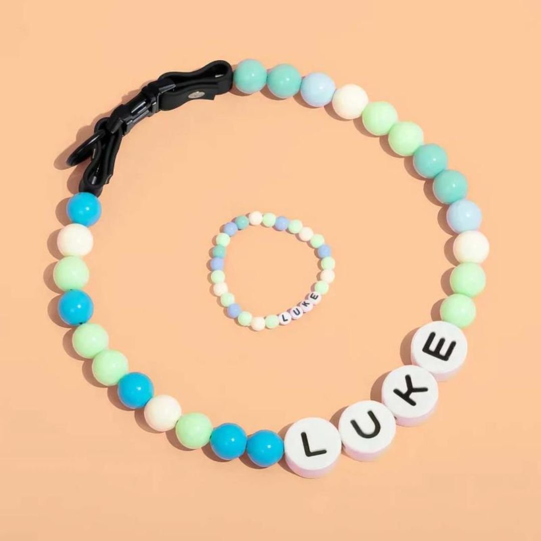 El Collar de cuentas personalizado para mascotas + Pulsera gratis, con broche negro y cuentas LUKE, se exhiben juntos sobre fondo durazno-un regalo ideal para amantes de mascotas.