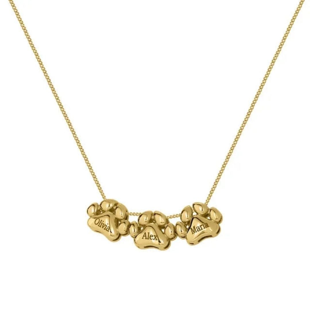El Collar de huellitas de mascotas personalizado en dorado incluye tres dijes de huellas grabados con los nombres Olivia, Alex y Maria, alineados en una delicada cadena para un toque personalizado.