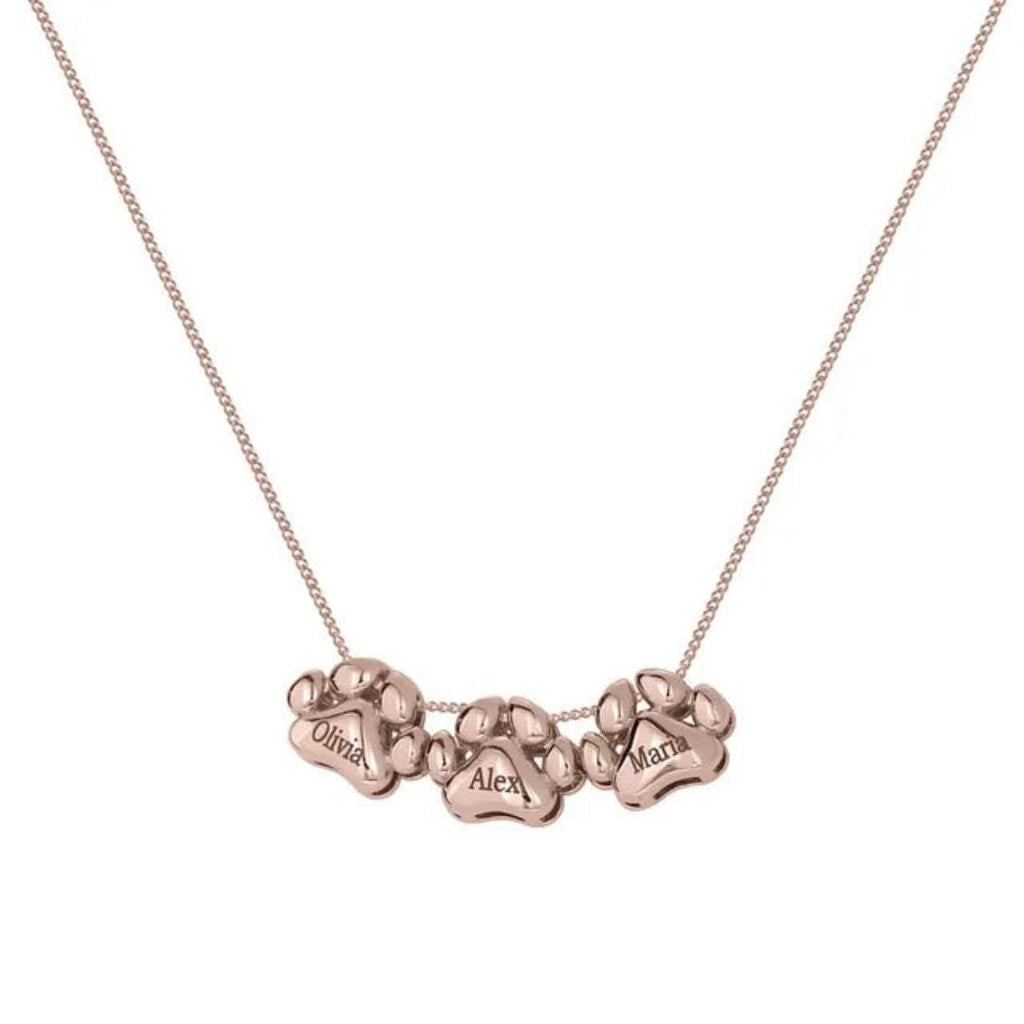El Collar de huellitas de mascotas personalizado en oro rosa lleva tres charms con huellas, cada uno grabado con los nombres de Olivia, Alex y Maria, para llevar a tus seres queridos siempre cerca.