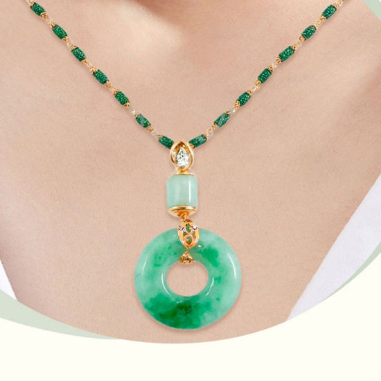 Primer plano de una persona que lleva el Collar de piedra jade esmeralda natural, un collar de cuentas verde jade con detalles dorados y un gran colgante circular de jade que exhibe una elegancia moderna y detalles intrincados.