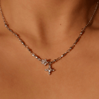 Detalle del collar Destello de estrella, un collar plateado con dos colgantes en forma de estrella con piedras transparentes, que se lleva alrededor del cuello.
