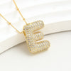El Collar Inicial Bubble, ahora en oferta de 2x1, presenta una gran letra E mayúscula cubierta de brillantes strass. Un collar dorado y personalizado, perfecto para regalar.