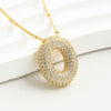 The Collar Inicial Bubble-¡Llévate 2 por el precio de 1!-es un elegante collar personalizado, ideal como regalo especial, con un colgante inicial estilizado que resalta sobre cualquier superficie blanca.