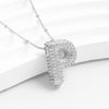 El Collar Inicial Bubble, en plata y con la inicial P decorada con piedras brillantes, es ideal como regalo personalizado. ¡Lévate 2 por el precio de 1! Se exhibe sobre un fondo blanco.