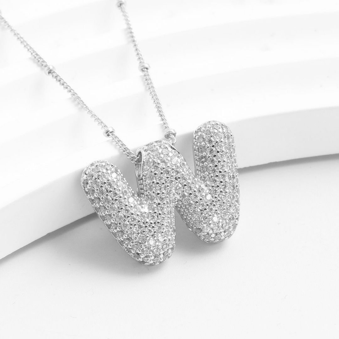 El Collar Inicial Bubble - ¡Llévate 2 por el precio de 1! luce una inicial W en plata con cristales brillantes, sobre fondo blanco texturizado-un regalo personalizado perfecto para alguien especial.