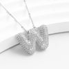 El Collar Inicial Bubble - ¡Llévate 2 por el precio de 1! luce una inicial W en plata con cristales brillantes, sobre fondo blanco texturizado-un regalo personalizado perfecto para alguien especial.