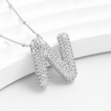 Cargar imagen en el visor de la galería, Descubre el Collar Inicial Bubble: un collar plateado con dije en forma de letra N decorado con cristales brillantes, sobre fondo blanco. ¡Llévate 2 por el precio de 1 y obsequia un regalo personalizado!.