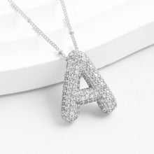 Cargar imagen en el visor de la galería, El collar Inicial Bubble - ¡Llévate 2 por el precio de 1! presenta un colgante de plata con forma de letra A, incrustado con piedras brillantes y sobre fondo blanco.