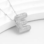 El Collar Inicial Bubble - ¡Llévate 2 por el precio de 1! luce elegante con su brillante inicial y detalles relucientes, ideal como regalo personalizado, presentado sobre fondo blanco.