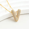El Collar Inicial Bubble, con dije en forma de V y brillantes piedras claras, se muestra sobre una superficie blanca-¡llévate 2 por el precio de 1! Un regalo personalizado ideal.
