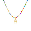 Collar Inicial colorido - ¡Llévate 3 por el precio de 1! Un collar con cuentas de colores y dije dorado con letra A, ideal como regalo para amigas. Se muestra sobre fondo blanco.