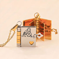 Un medallón dorado y plateado en forma de libro con un corazón recortado, grabado con una madre y su hijo, un regalo ideal: Collar Libro a mi nieta - "Tú siempre estarás en mi corazón"- se abre para revelar páginas doradas y un mensaje personalizado.