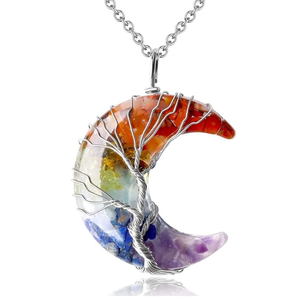 El collar "Luna mística" destaca por su colgante de luna creciente adornado con piedras naturales arcoíris y un Árbol de la Vida en alambre plateado, colgado en una elegante cadena plateada.