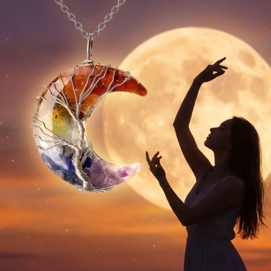 Una mujer silueteada por la luna llena levanta los brazos con gracia. En primer plano, el collar "Luna mística" forma una media luna, sus piedras naturales crean una ilusión de cristales flotando en el cielo.