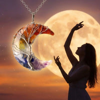 Una mujer silueteada por la luna llena levanta los brazos con gracia. En primer plano, el collar "Luna mística" forma una media luna, sus piedras naturales crean una ilusión de cristales flotando en el cielo.