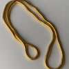 El Collar moldeable multiuso, una cadena flexible de acero inoxidable de color dorado, se despliega sobre una superficie lisa y clara en bucles sueltos y superpuestos.